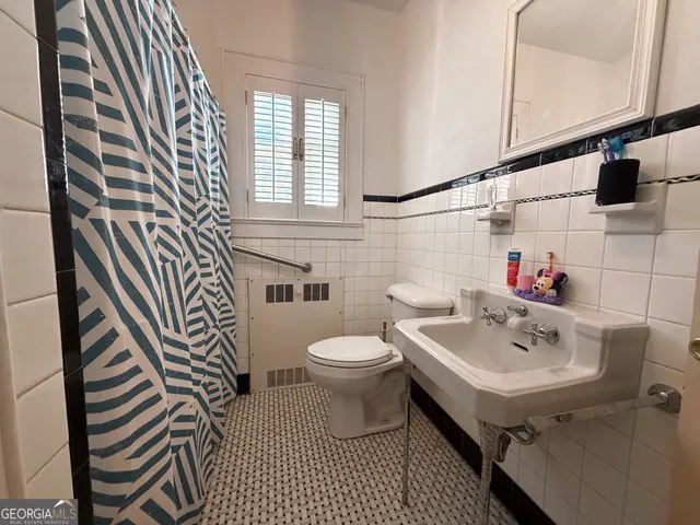 a bathroom with a sink a toilet and a mirror