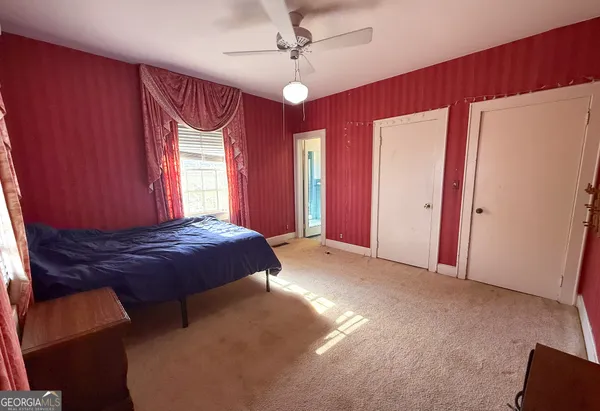 a spacious bedroom with a bed and a chandelier