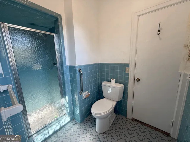 a bathroom with a toilet and a shower