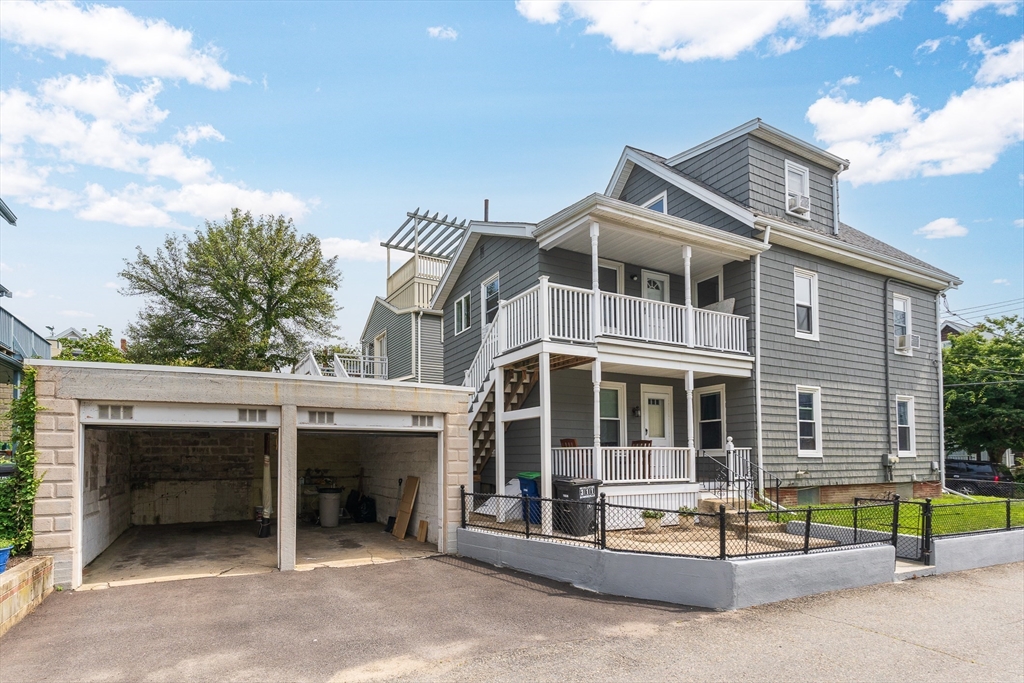 16 Porter Street, Unit 2 Somerville, MA 02143 - Photo 1 of 26 a front view of a house with a garage and balcony