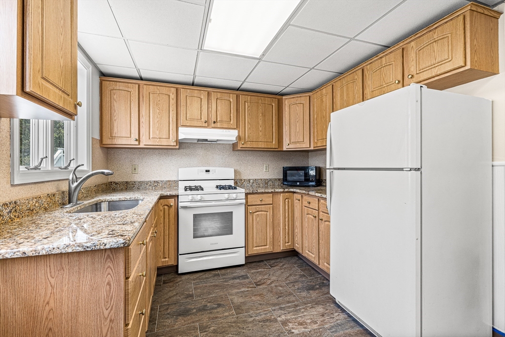 16 Porter Street, Unit 2 Somerville, MA 02143 - Photo 5 of 26 a kitchen with stainless steel appliances granite countertop a refrigerator sink stove and cabinets