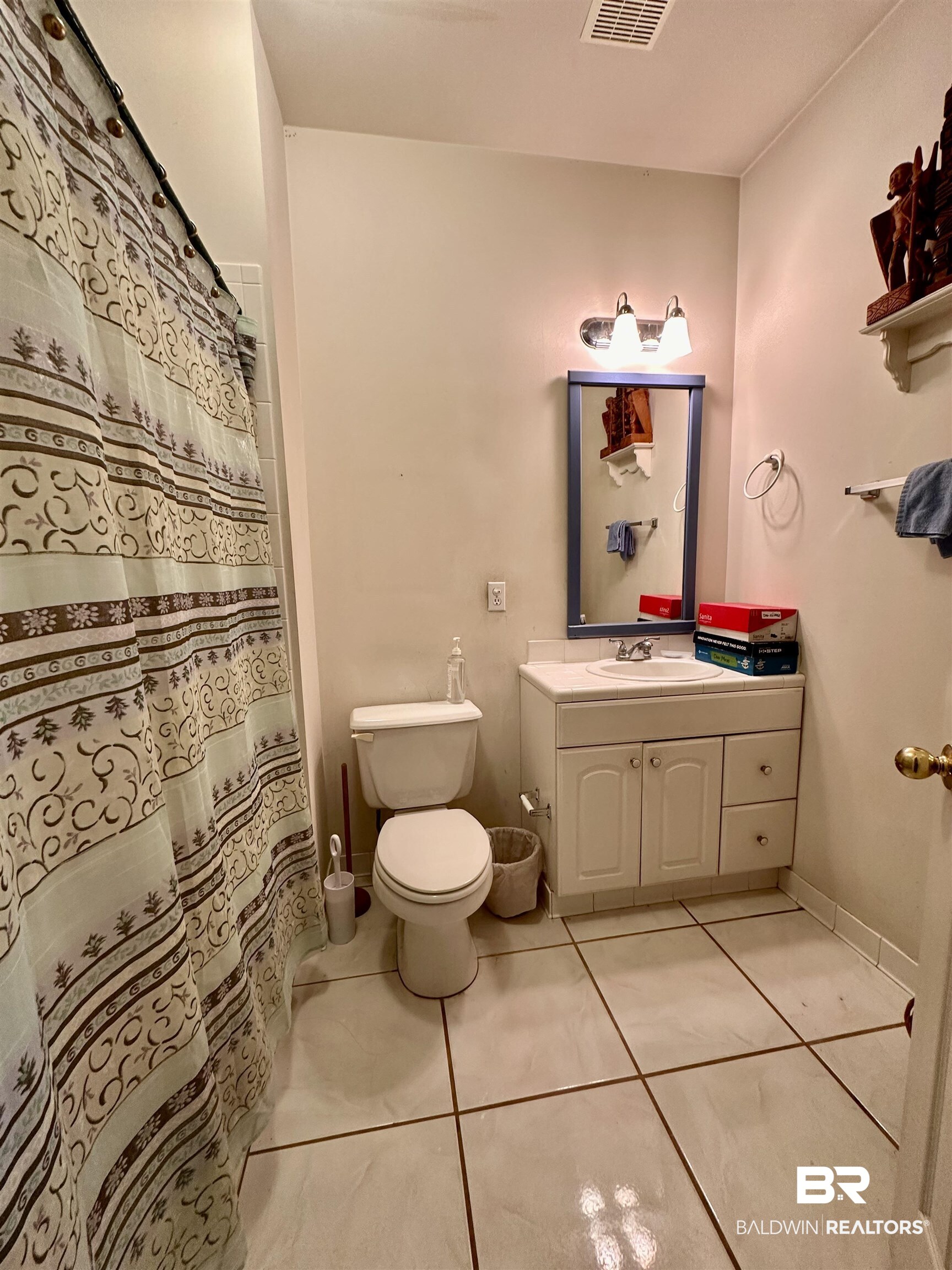 9101 Coronada Road Elberta, AL 36530 - Photo 9 of 27 Bathroom with light tile patterned flooring, vanity, and a shower with curtain
