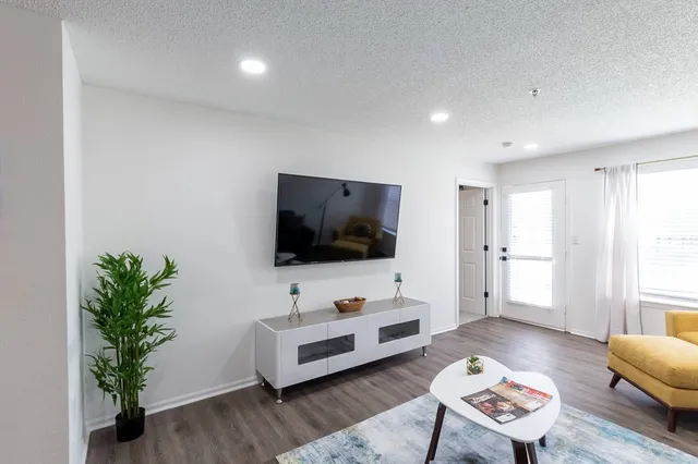 a kitchen with stainless steel appliances a sink dishwasher a stove top oven a refrigerator with wooden floors