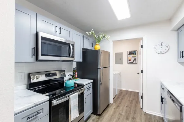 a kitchen with stainless steel appliances a stove microwave and a refrigerator