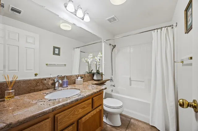 a bathroom with a granite countertop sink toilet and shower