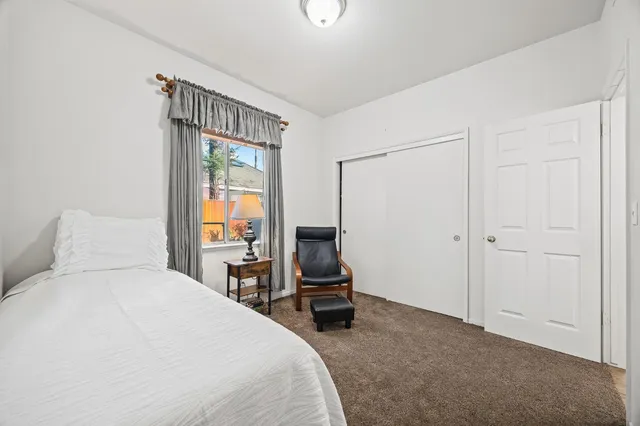 a bedroom with a bed and large window