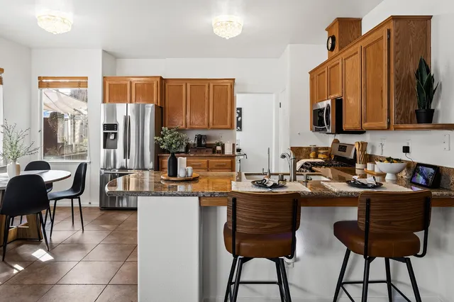a kitchen with a dining table chairs and a refrigerator