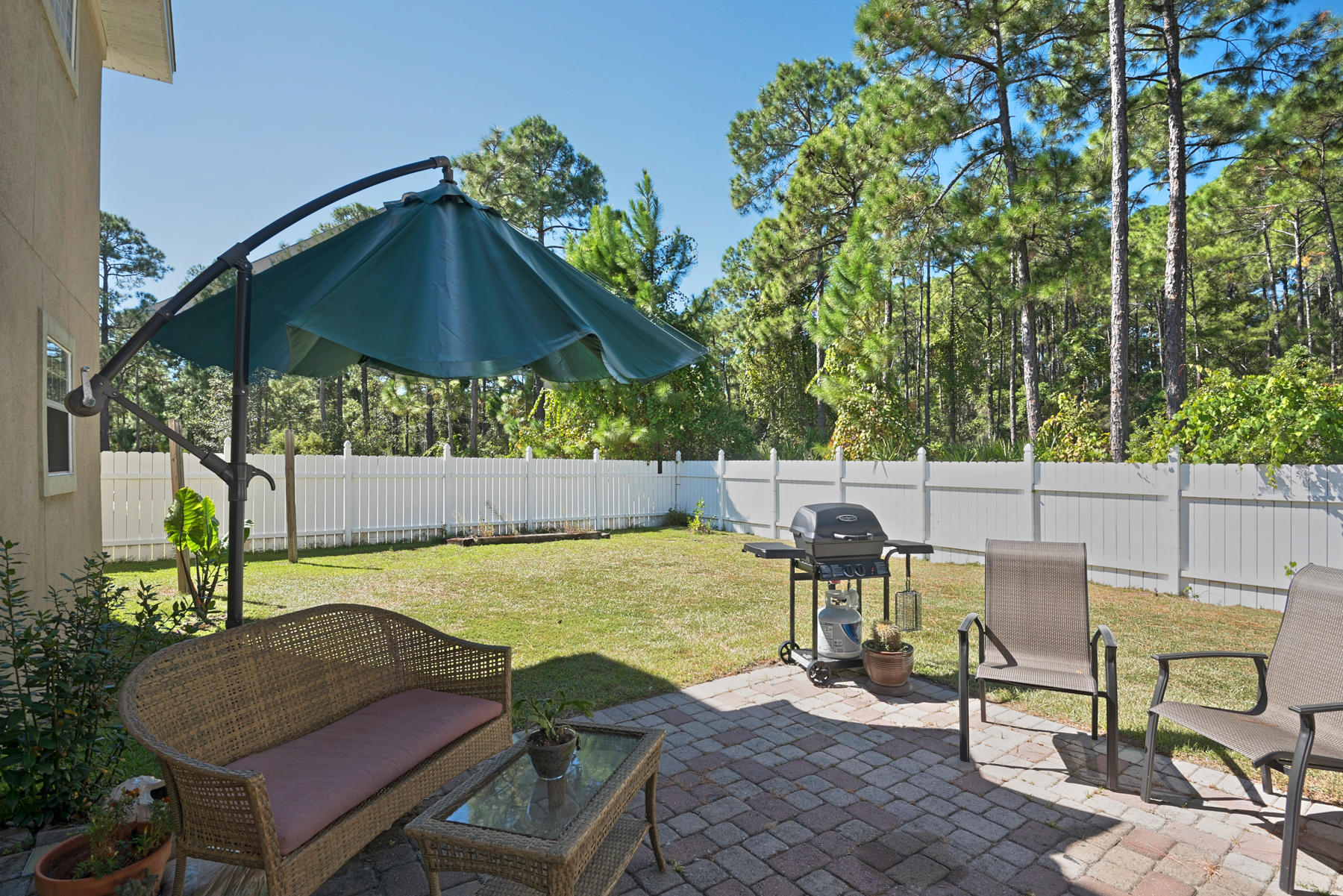 30 Red Maple Court Santa Rosa Beach, FL 32459 - Photo 17 of 36 a view of a patio with table and chairs under an umbrella