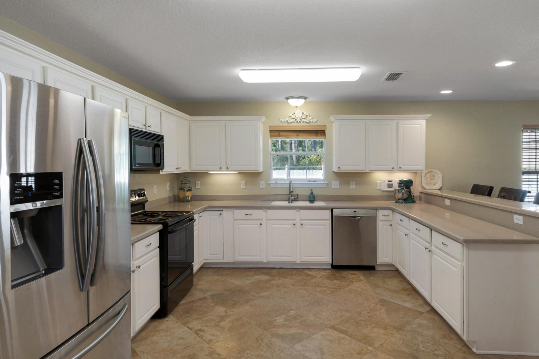 30 Red Maple Court Santa Rosa Beach, FL 32459 - Photo 23 of 36 a kitchen with granite countertop a refrigerator sink and white cabinets