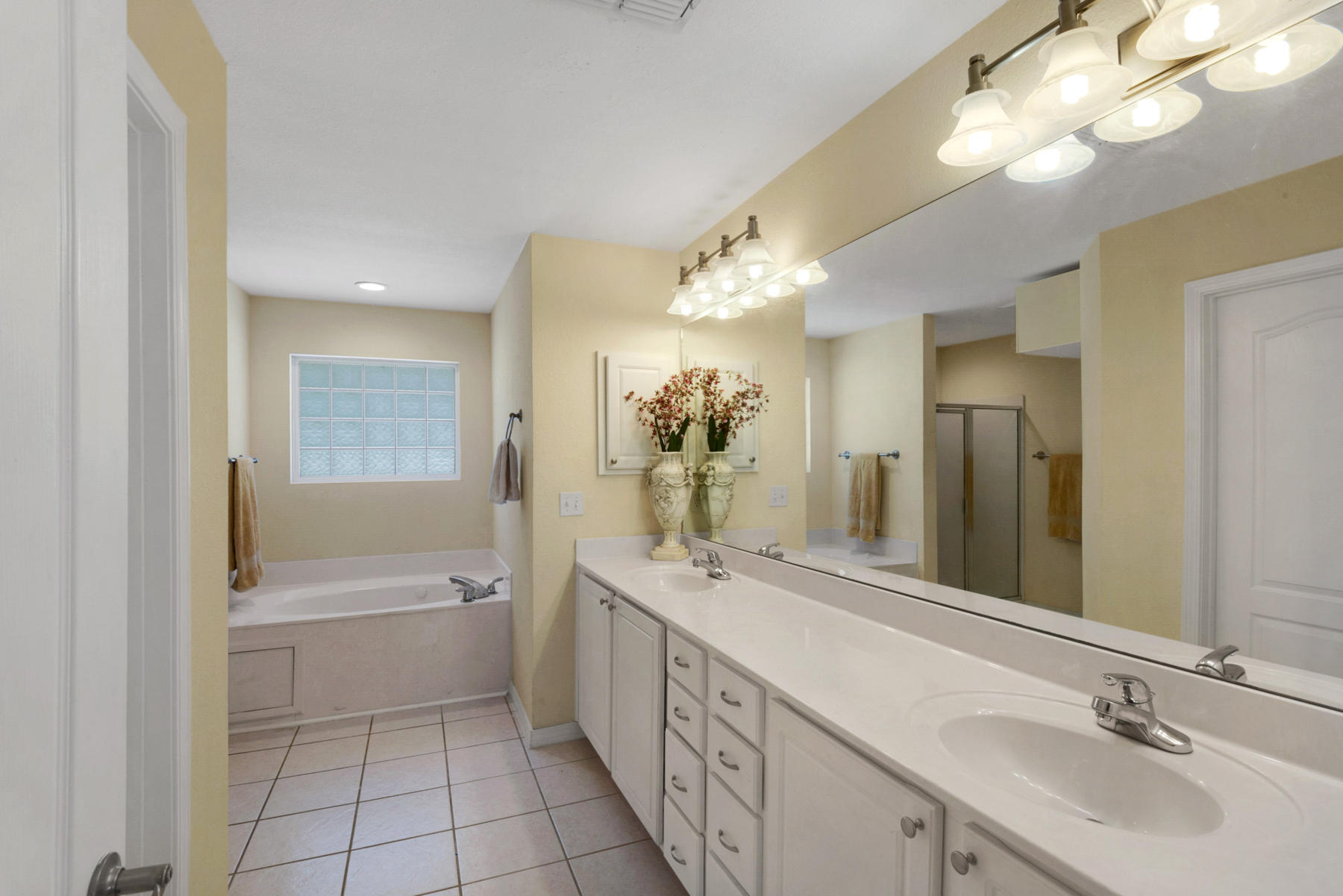 30 Red Maple Court Santa Rosa Beach, FL 32459 - Photo 29 of 36 a bathroom with a double vanity sink a large mirror and a bathtub