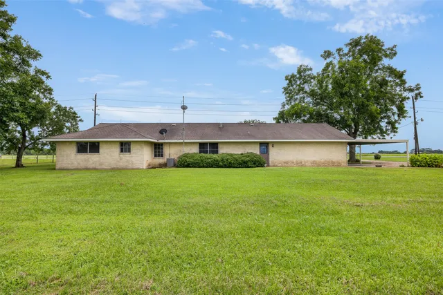 a front view of a house with a yard and trees