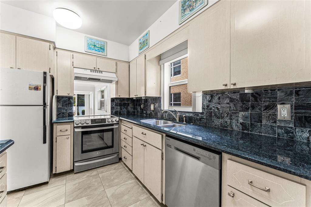 2758 Northeast 30th Avenue, Unit 1A Lighthouse Point, FL 33064 - Photo 24 of 48 a kitchen with stainless steel appliances granite countertop a sink stove and refrigerator