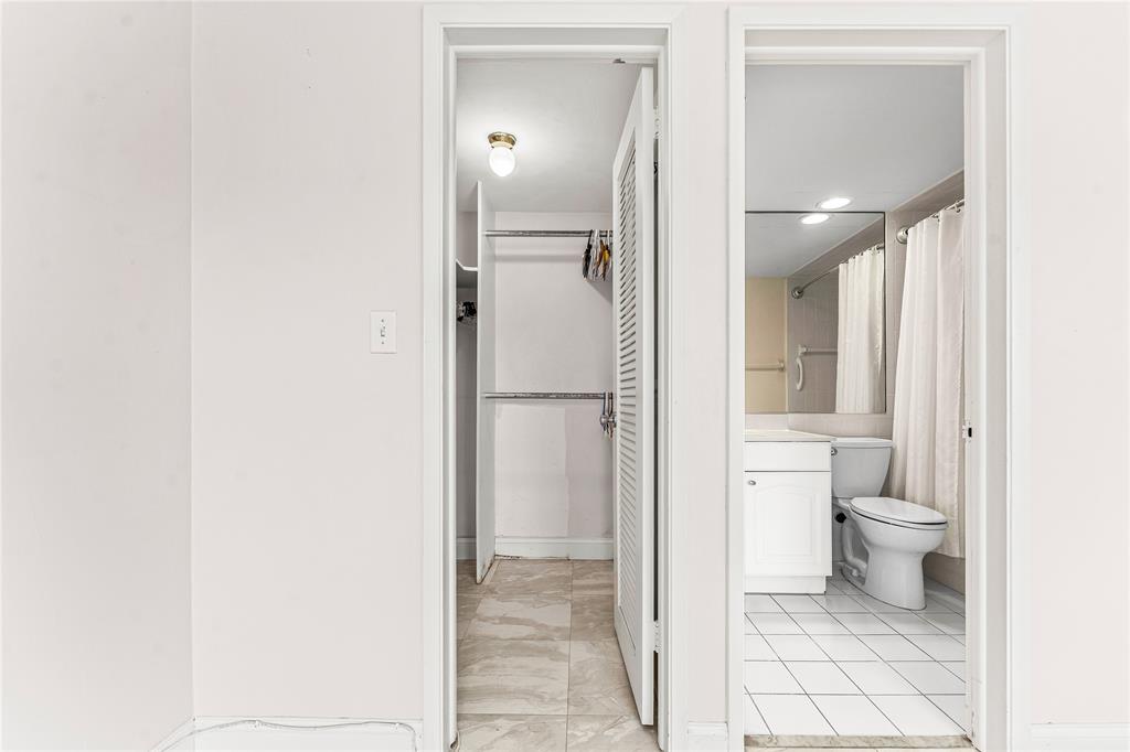2758 Northeast 30th Avenue, Unit 1A Lighthouse Point, FL 33064 - Photo 36 of 48 a bathroom with a granite countertop toilet and a shower