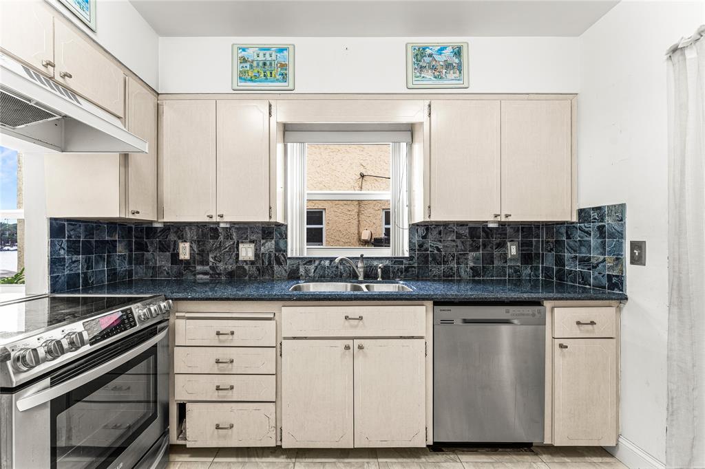 2758 Northeast 30th Avenue, Unit 1A Lighthouse Point, FL 33064 - Photo 6 of 48 a kitchen with granite countertop a sink and a stove