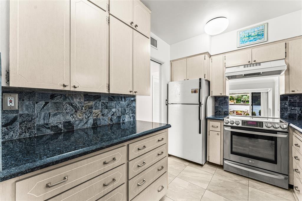 2758 Northeast 30th Avenue, Unit 1A Lighthouse Point, FL 33064 - Photo 7 of 48 a kitchen with stainless steel appliances granite countertop a refrigerator a stove and white cabinets