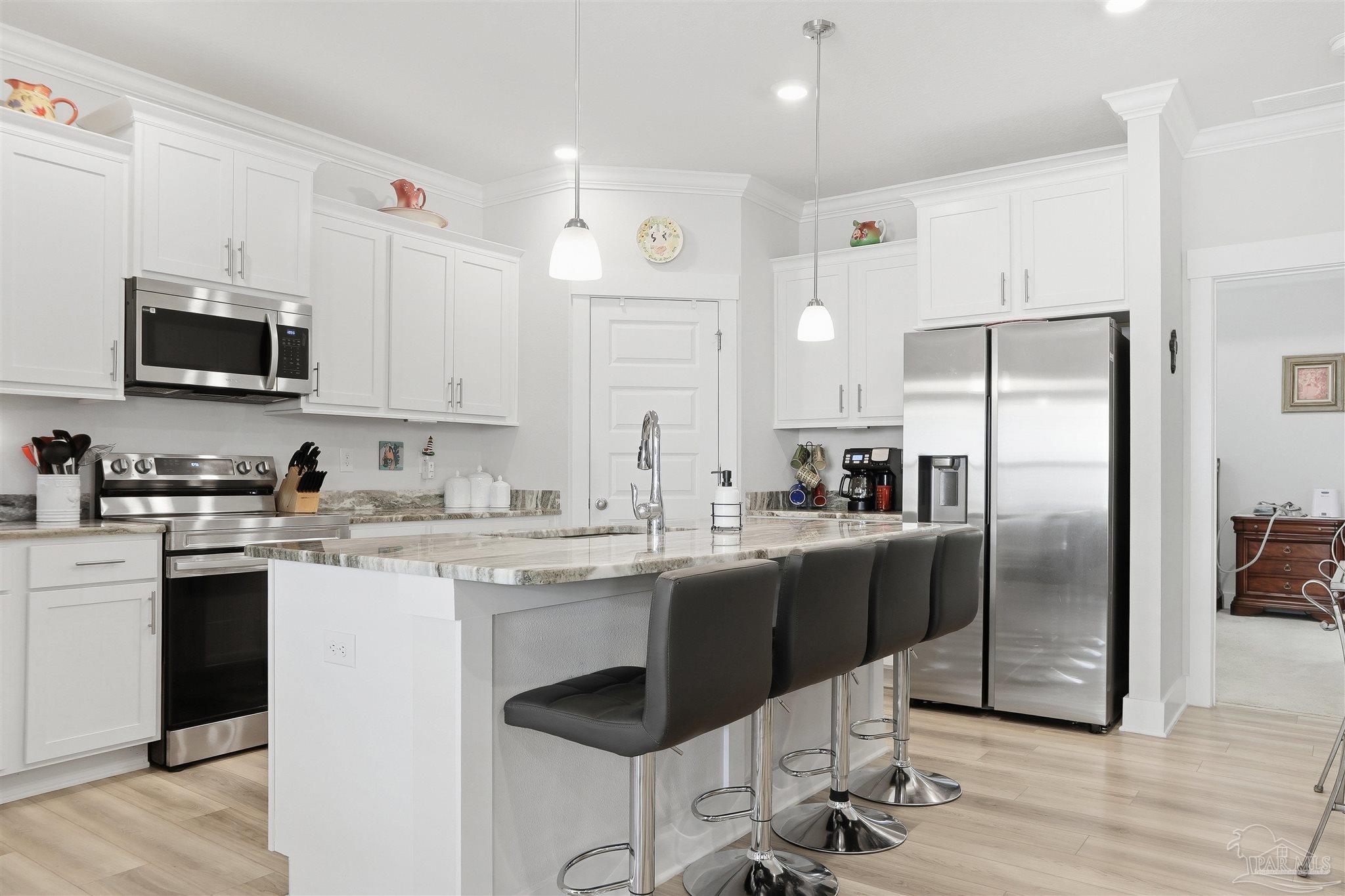 1932 Appleton Drive Cantonment, FL 32533 - Photo 17 of 57 a kitchen with stainless steel appliances granite countertop a stove a sink a microwave a refrigerator and cabinets