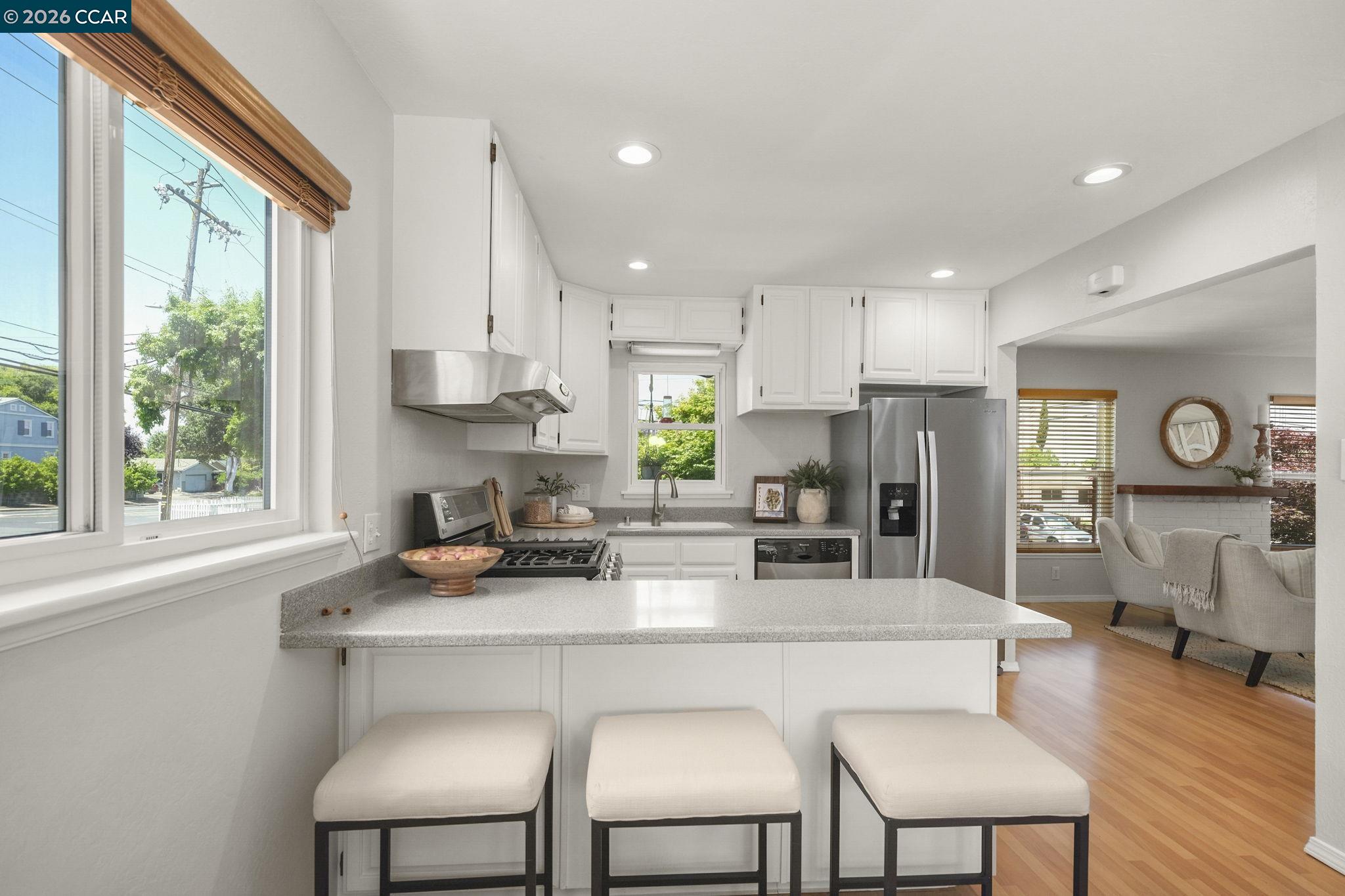 4311 Cowell Road Concord, CA 94521 - Photo 13 of 29 a kitchen with stainless steel appliances a dining table chairs and a refrigerator