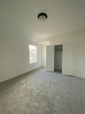 an empty room with a fan and windows
