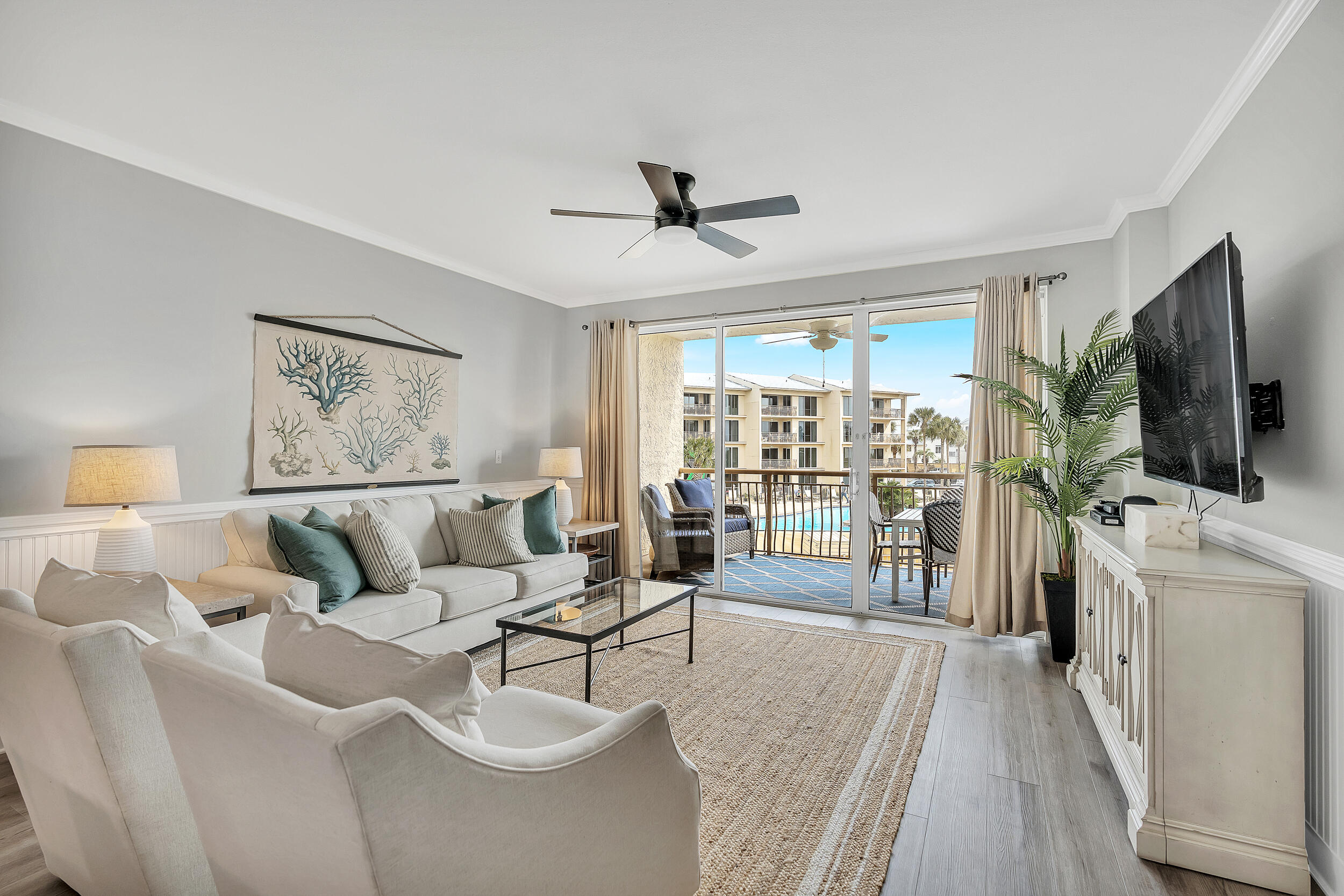 10254 East Co Highway, Unit 233 Inlet Beach, FL 32461 - Photo 13 of 46 a living room with furniture a flat screen tv and a floor to ceiling window