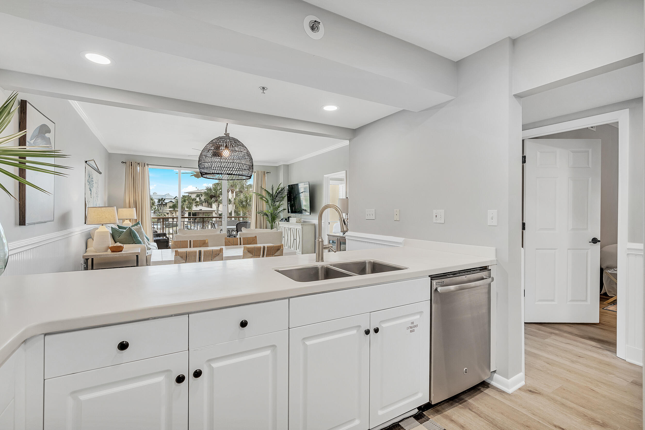 10254 East Co Highway, Unit 233 Inlet Beach, FL 32461 - Photo 6 of 46 a kitchen with kitchen island a sink and white cabinets with wooden floor