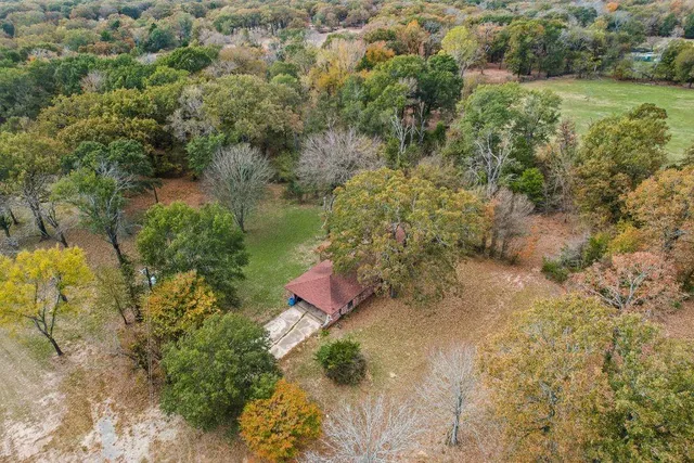 a house is sitting in middle of the middle of a field
