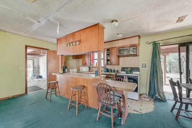 a bathroom with a granite countertop sink toilet and painting on the wall