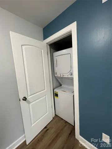 a utility room with wooden floor washer and dryer