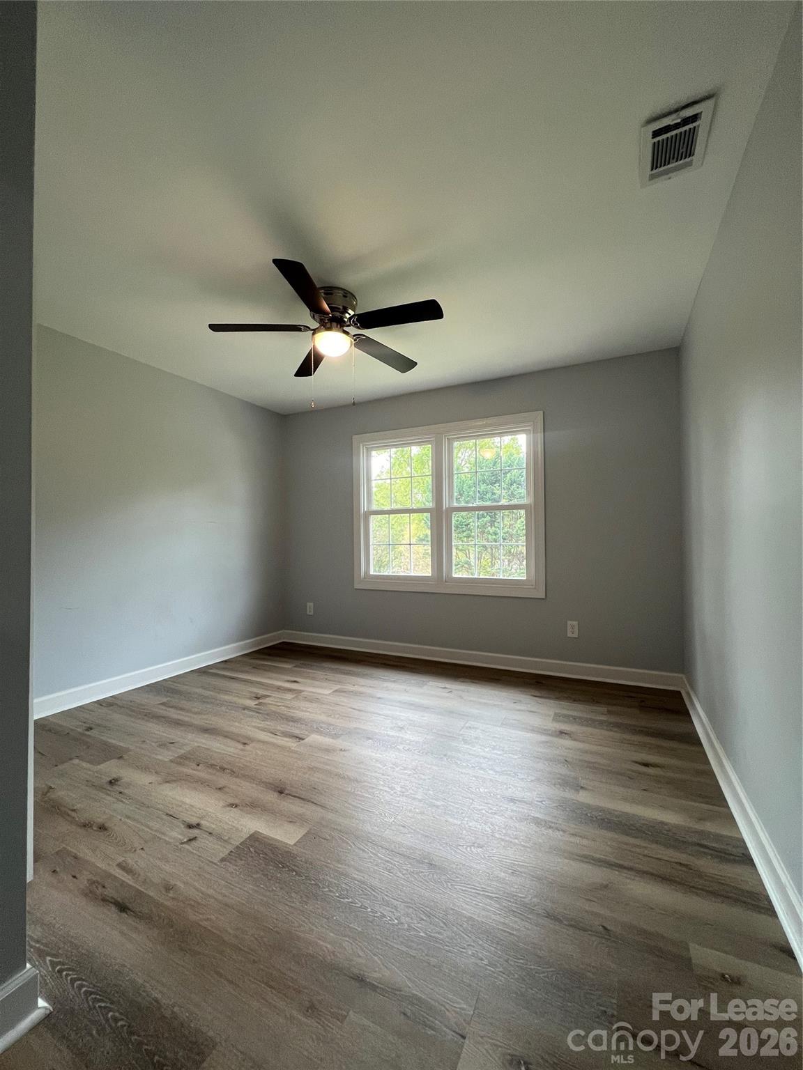 1048 Avondale Road, Unit 13 Lowell, NC 28098 - Photo 6 of 9 an empty room with wooden floor fan and windows