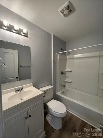 a bathroom with a sink a toilet a mirror and shower