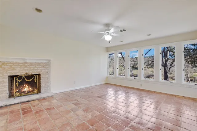 a view of an empty room with window and fireplace