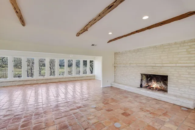a view of an empty room with a fireplace and a floor to ceiling window