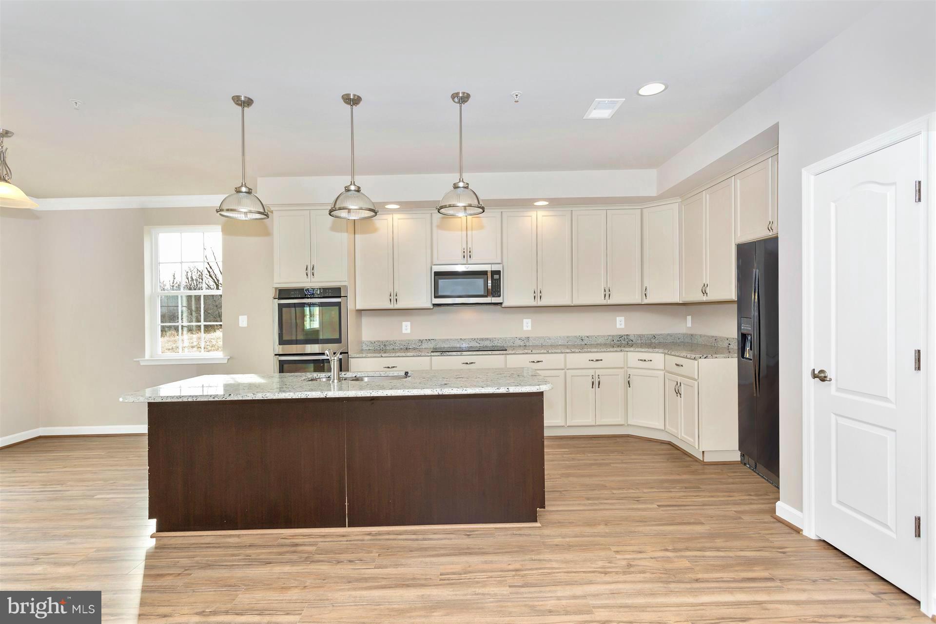 5305 Renn Road Frederick, MD 21703 - Photo 9 of 13 a kitchen with stainless steel appliances granite countertop a sink a stove a refrigerator and white cabinets with wooden floor