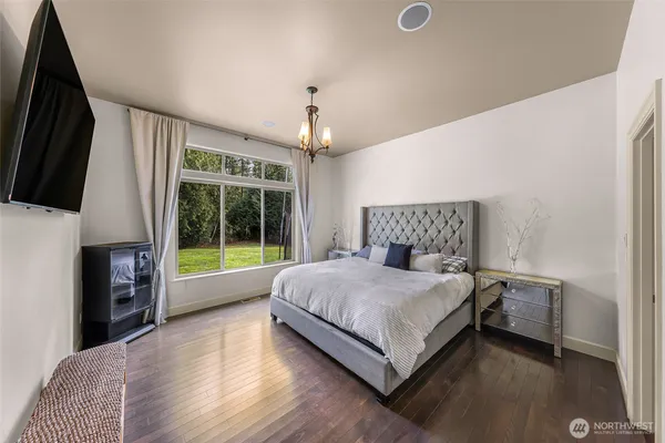 a living room with a bed furniture flat screen tv and a large window