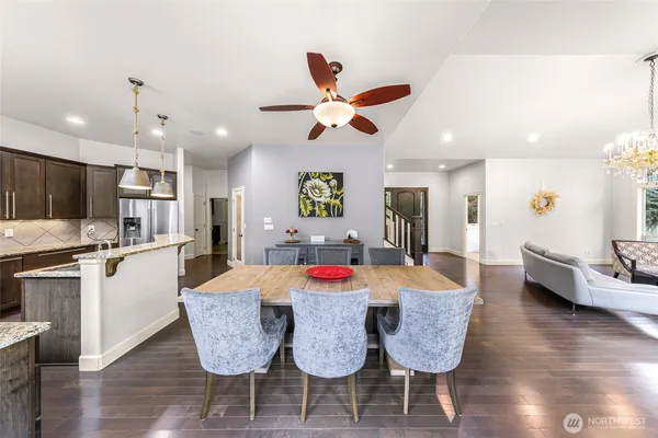 a dining room with stainless steel appliances furniture a window and kitchen view
