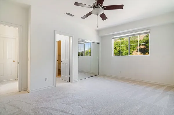 an empty room with windows and closet