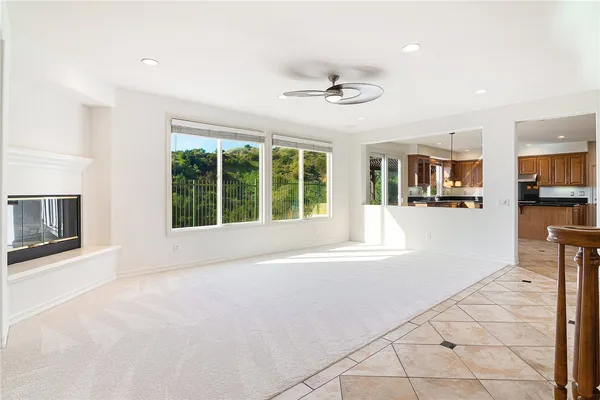 a view of an empty room with kitchen view and a window