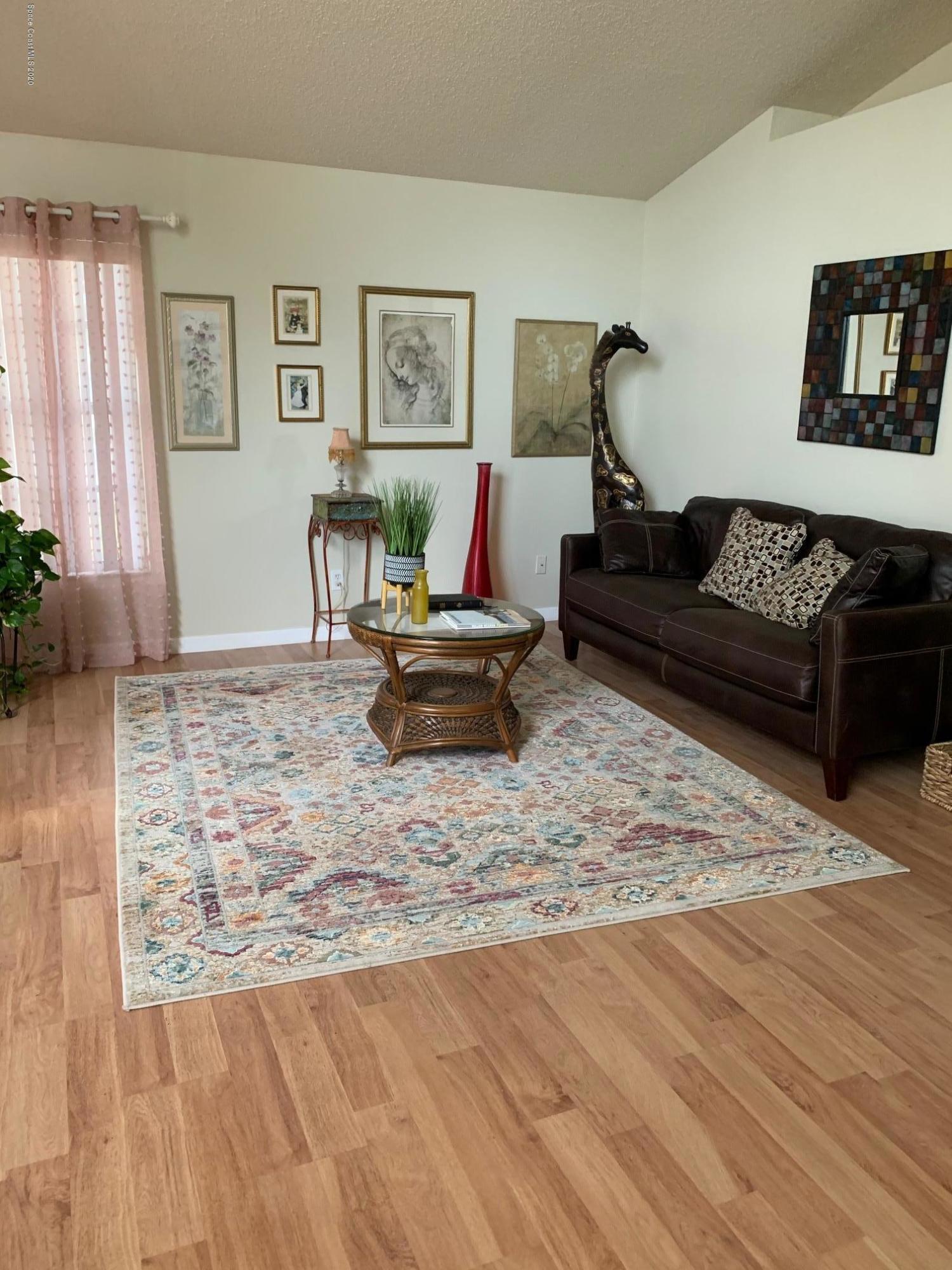 3358 Lakeview Circle Melbourne, FL 32934 - Photo 3 of 14 a living room with furniture and painting on the wall