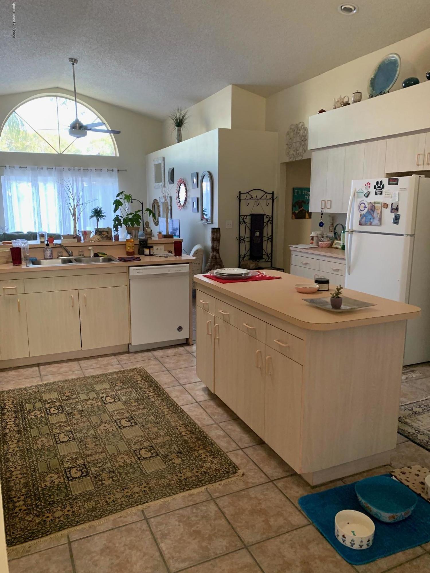 3358 Lakeview Circle Melbourne, FL 32934 - Photo 5 of 14 a kitchen with granite countertop a sink stove and cabinets