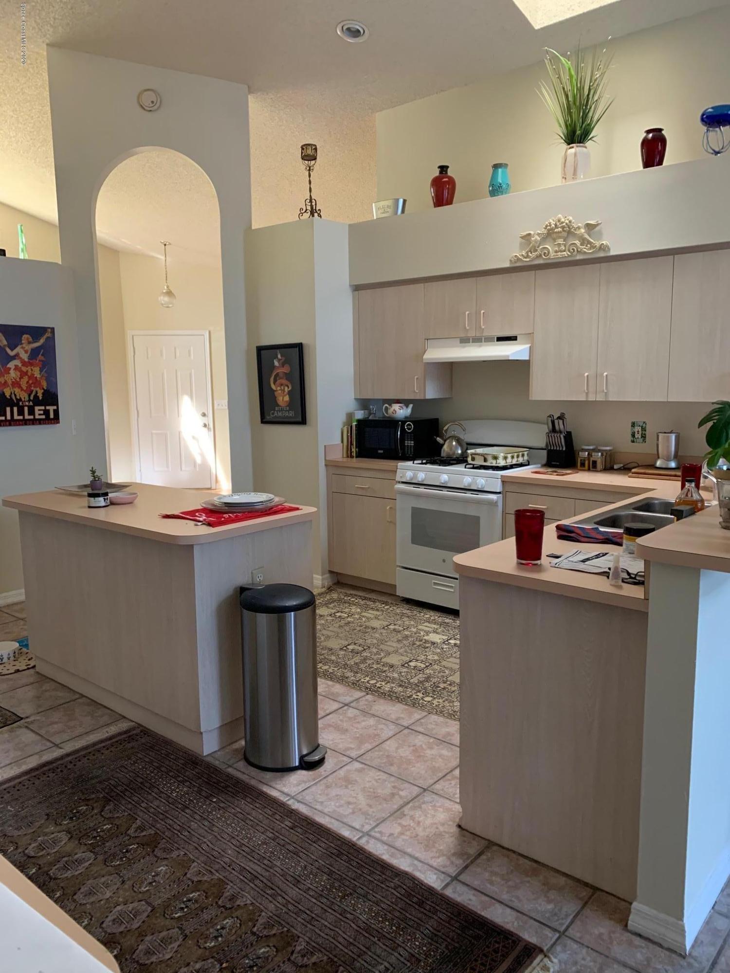 3358 Lakeview Circle Melbourne, FL 32934 - Photo 6 of 14 a kitchen with stainless steel appliances granite countertop a stove a sink and a refrigerator