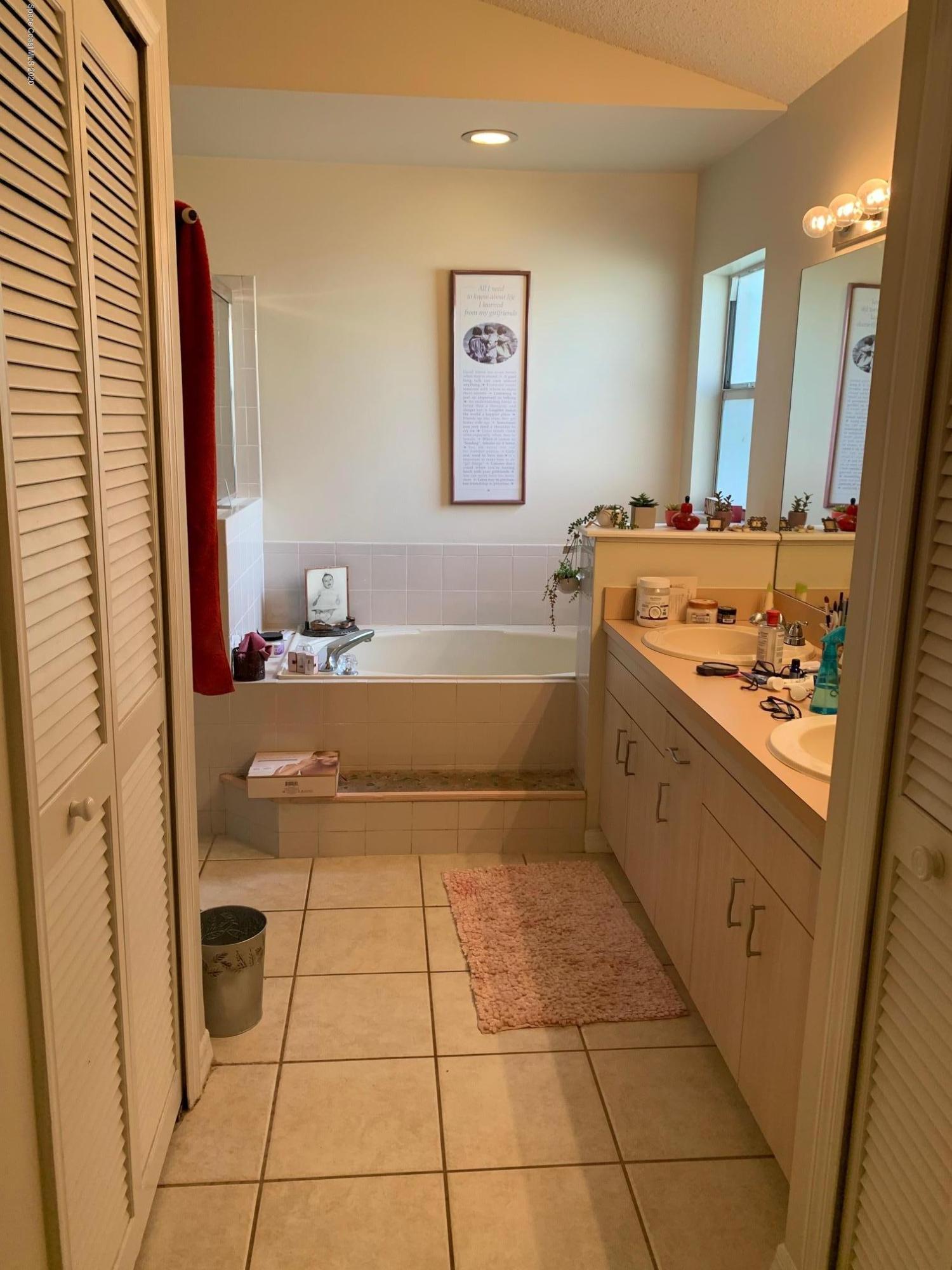 3358 Lakeview Circle Melbourne, FL 32934 - Photo 9 of 14 a bathroom with a tub sink and mirror