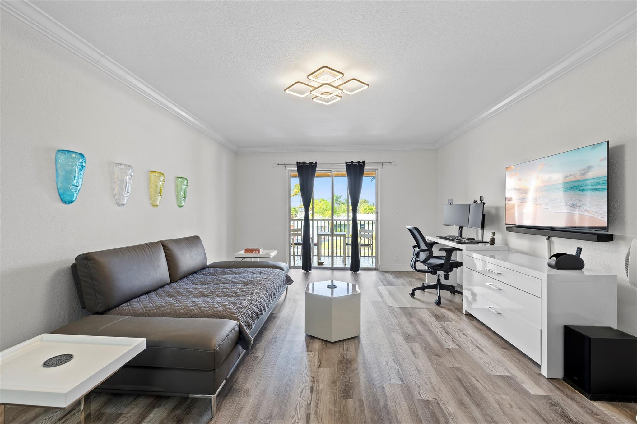 101 East McNab Road, Unit 219 Pompano Beach, FL 33060 - Photo 3 of 26 a living room with furniture a flat screen tv and a large window