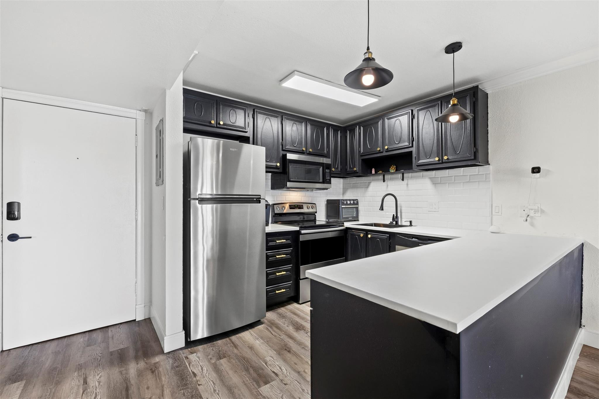 101 East McNab Road, Unit 219 Pompano Beach, FL 33060 - Photo 10 of 26 a kitchen with stainless steel appliances a stove microwave sink refrigerator and cabinets