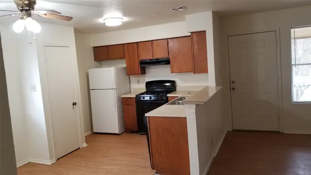 a kitchen with refrigerator and cabinets