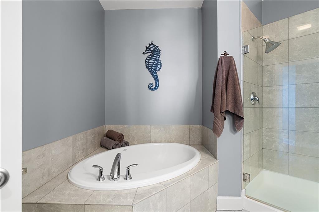 325 East Paces Ferry Road Northeast, Unit 1711 Atlanta, GA 30305 - Photo 12 of 29 a bathroom with a tub and a shower