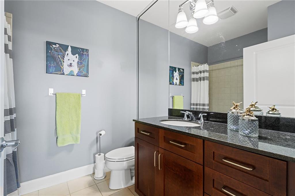 325 East Paces Ferry Road Northeast, Unit 1711 Atlanta, GA 30305 - Photo 13 of 29 a bathroom with a granite countertop sink a toilet and a mirror