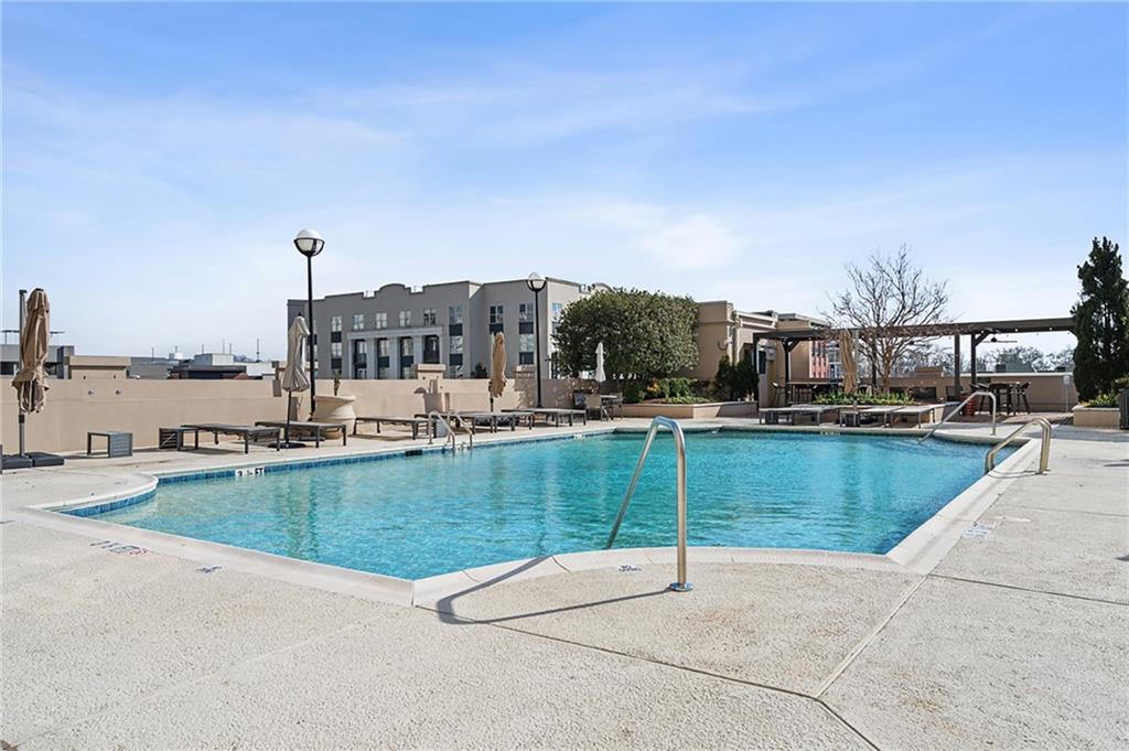 325 East Paces Ferry Road Northeast, Unit 1711 Atlanta, GA 30305 - Photo 23 of 29 a view of a swimming pool with a lawn chairs