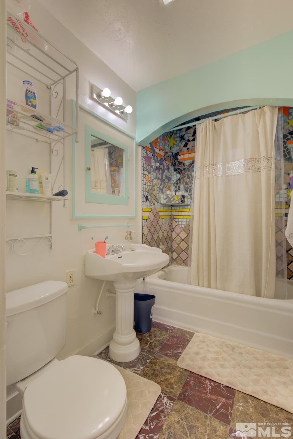 321 Crampton Street, Unit 1/2 Reno, NV 89502 - Photo 17 of 40 a bathroom with a sink a toilet and shower curtain