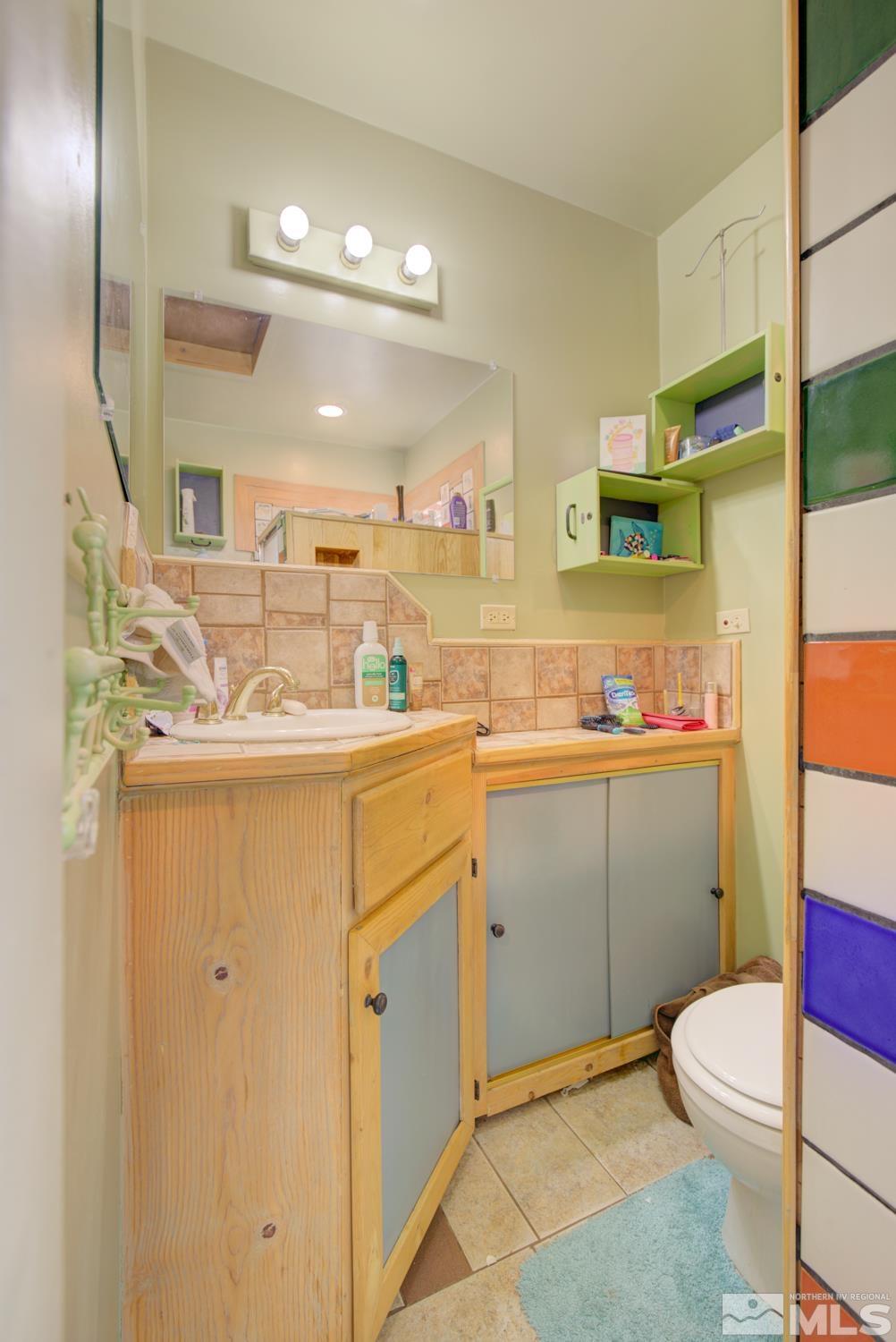 321 Crampton Street, Unit 1/2 Reno, NV 89502 - Photo 27 of 40 a bathroom with a sink a toilet and mirror