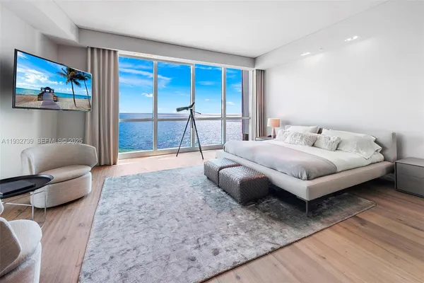 a spacious bedroom with a bed and glass window