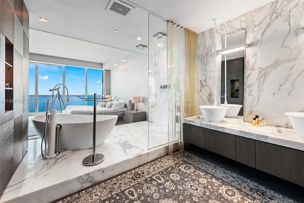 a large bathroom with a tub sink and mirror